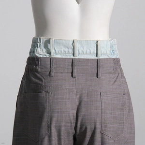 Détail du pantalon à carreaux contrasté avec double taille en denim et poches arrière