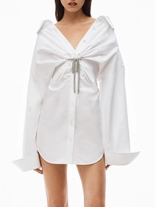 Robe chemise blanche oversize avec décolleté en V profond et broche nœud en strass