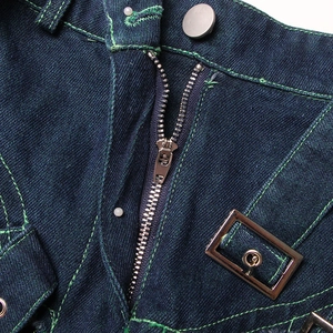 Detail of dark blue denim skirt with green contrast stitching and metal zipper hardware