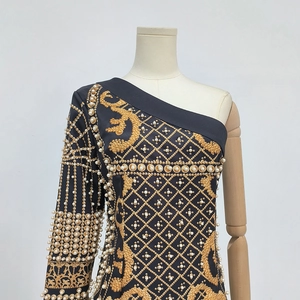 Détail de la robe baroque noire et dorée avec perles et broderies de haute qualité