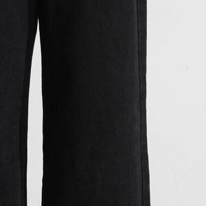 Dettaglio della trama del denim nero e cuciture precise sui jeans a gamba larga