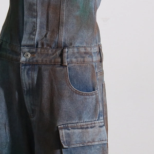 Détail de la combinaison en jean camouflage vintage avec bouton en métal et poche cargo