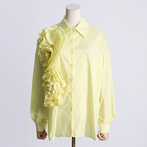 Dettaglio della grande decorazione floreale 3D plissettata su questa camicia gialla