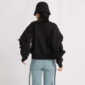 Rear view of black sweatshirt with pleated sleeves and light blue drawstring cargo pants
