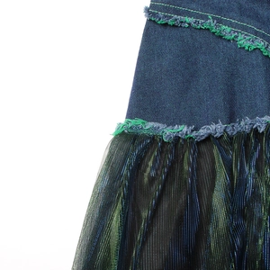 Detail of denim and mesh stitching with green contrast stitching and frayed edges