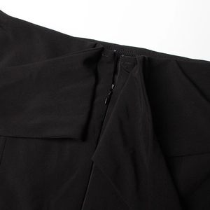 Détail de la fermeture éclair invisible sur une élégante combinaison noire ajustée