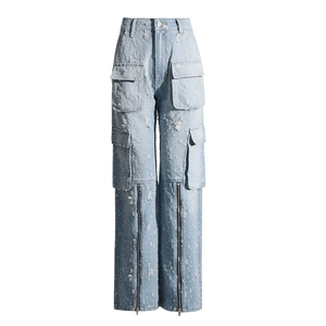 Détail du jean bleu clair avec grandes poches cargo et fermetures éclair décoratives