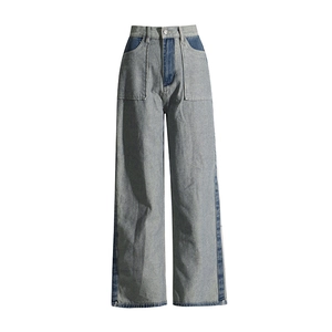 Detail view of high-waisted wide-leg jeans with contrast denim patchwork and square pockets
