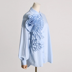 Vista dettagliata della camicia celeste con fiore plissettato 3D e colletto classico