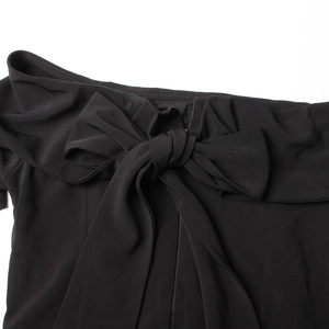 Détail du grand nœud papillon sur l'encolure de cette élégante combinaison noire à épaules nues