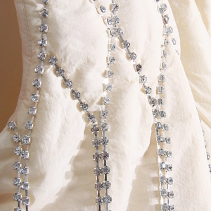 Detailed view of white pleated fabric adorned with elegant sparkling rhinestone chains