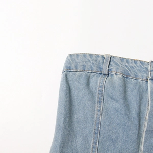 Detailed view of light blue washed denim with waist belt loops and precision stitching