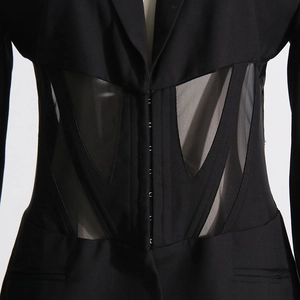 Detailed close-up of mesh corset waist paneling on a black tailored blazer jacket