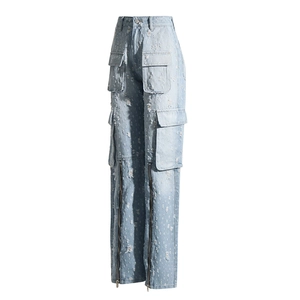 Détail du jean bleu clair à jambes larges avec déchirures et longues poches à zip métal