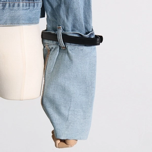 Detail of light blue denim sleeve with black leather belt accent and pleated texture