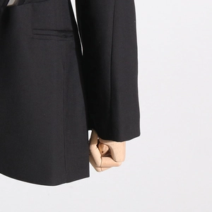 Detailed view of black blazer pocket and sleeve cuffs with structured premium fabric