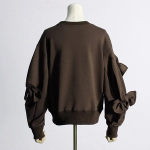 Detail view of large bows on the back of a dark brown long-sleeve crewneck sweatshirt