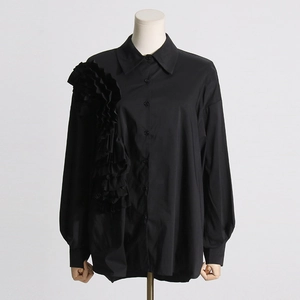 Dettaglio delle balze 3D a fiore su questa camicia nera a maniche lunghe dal design moderno