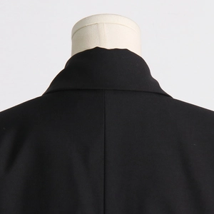 Close-up of a black blazer featuring French boned corset waist and mesh panels