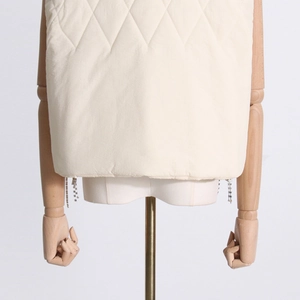 Close-up of diamond-quilted vest hem featuring intricate metal bead tassel zipper detail