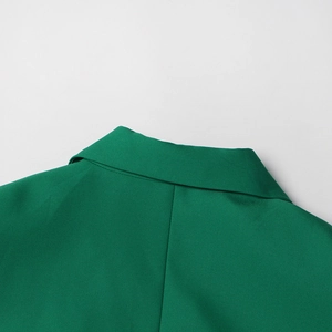 Détail du col et de l'épaule d'un blazer vert avec des coutures de haute précision