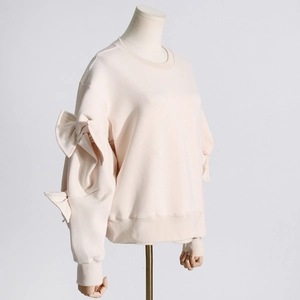 Detailed view of the elegant bow-tie stitching on the sleeve of this stylish pink sweatshirt