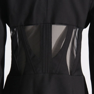 Detail view of the fishbone corset waist with sheer mesh panels on a black blazer