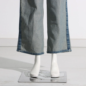 Detailed view of light blue wide-leg jeans with contrast side stitching and washed hem