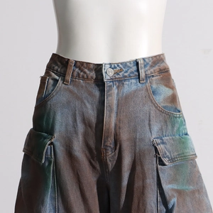 Detail of high waist tie-dye cargo jeans featuring large flap pockets and metal button