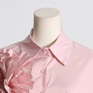 Dettaglio camicia in cotone rosa con decorazione floreale 3D plissettata sulla spalla