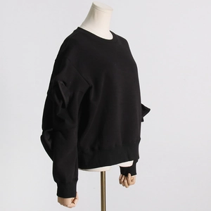 Detail view of stylish black crewneck sweatshirt featuring unique pleated sleeve design