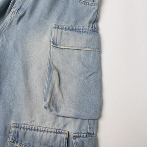 Close-up of light blue wash denim cargo jumpsuit with large flap pockets and stitching