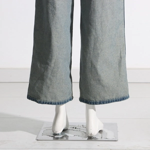 Detail view of light blue wide-leg jeans with contrast stitching and washed denim texture
