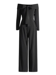 Combinaison noire élégante à épaules dénudées avec grand nœud et pantalon large fluide