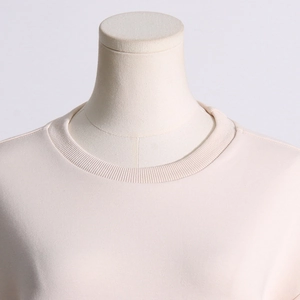 Close-up of the ribbed crewneck and fine stitching on this light pink sweatshirt