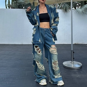 Dettaglio di un set denim blu lavato vintage con effetti strappati e bordi sfilacciati
