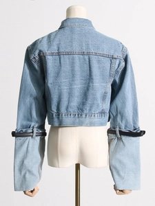 Light blue cropped denim jacket with oversized sleeves and black leather belt details