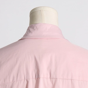 Dettaglio del colletto e del carrè di una camicia rosa con cuciture rifinite