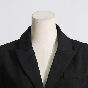 Close-up of black tailored blazer with peak lapels and structured shoulder on mannequin