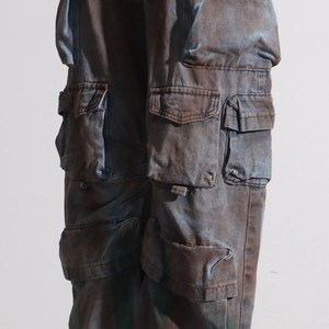 Detailed close-up of multi-pocket utility cargo pants with vintage washed texture