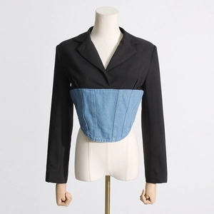 Detailed close-up of the blazer with denim patchwork waist and slimming corset stitching