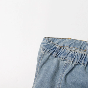 Macro shot of light blue denim waist with elastic band and detailed double-needle stitching