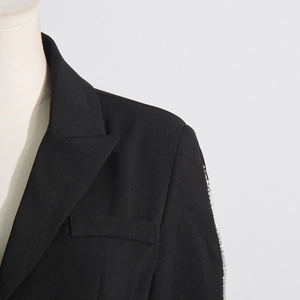 Detailed view of rhinestone sleeves and classic notched lapel on a black blazer jacket