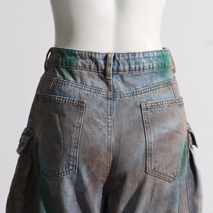 Detail view of tie-dye cargo jeans featuring back pockets and distressed wash finish