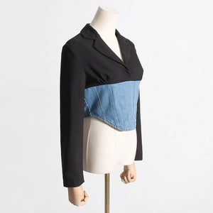Detail of hybrid blazer featuring black suiting fabric and corset-style denim waist panel