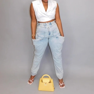 Détail du jean taille haute avec de grandes poches latérales et un denim bleu clair