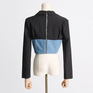 Detail of slim-fit blazer with black fabric, denim patchwork and back metal zipper