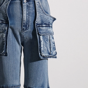 Detailed macro view of acid wash blue denim cargo pants with 3D utility pockets