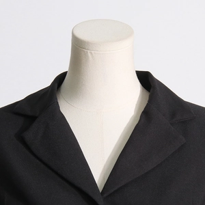 Close-up of lapel and shoulder tailoring on a slim-fit black denim patchwork blazer
