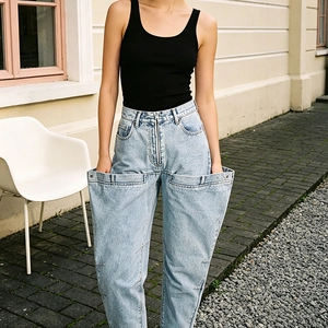 Détail de jean taille haute avec poches doubles pliables au design structuré unique
